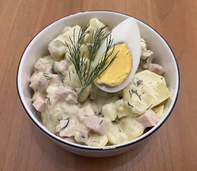 Sächsischer Kartoffelsalat mit Mayonnaise aus Pellkartoffeln, mit Ei, Gewürzgurke und Fleischwurst