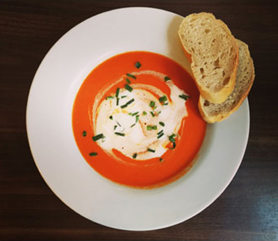 Tomatencremesuppe, mit einem Klecks Sahne und Schnittlauch verfeinert