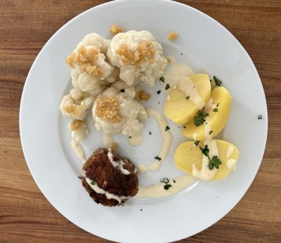 Bulette, Salzkartoffeln und Blumenkohl mit Käsesoße