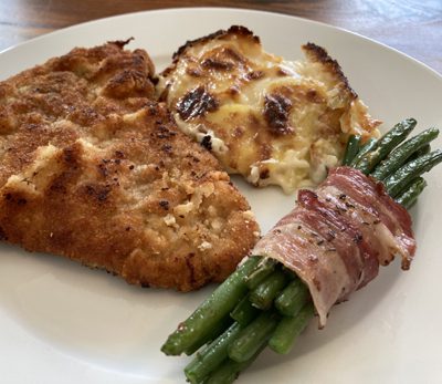 Schweineschnitzel mit Bohnen im Speckmantel dazu Kartoffelgratin