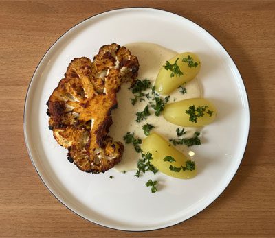 Mariniertes Blumenkohlsteak mit Salzkartoffeln und Käsesoße